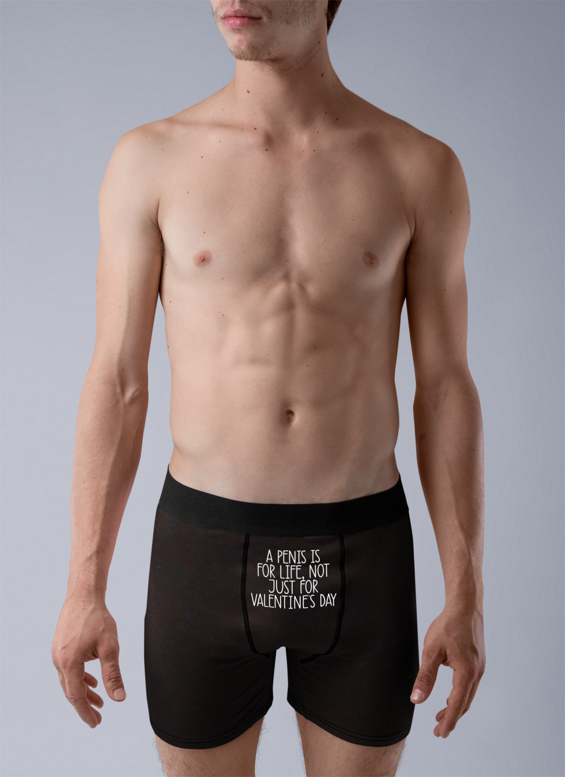 Black pair of mens boxer short pants with a white funny quote to the top middle section.. It reads 'a penis is for life, not just for valentine's day'.