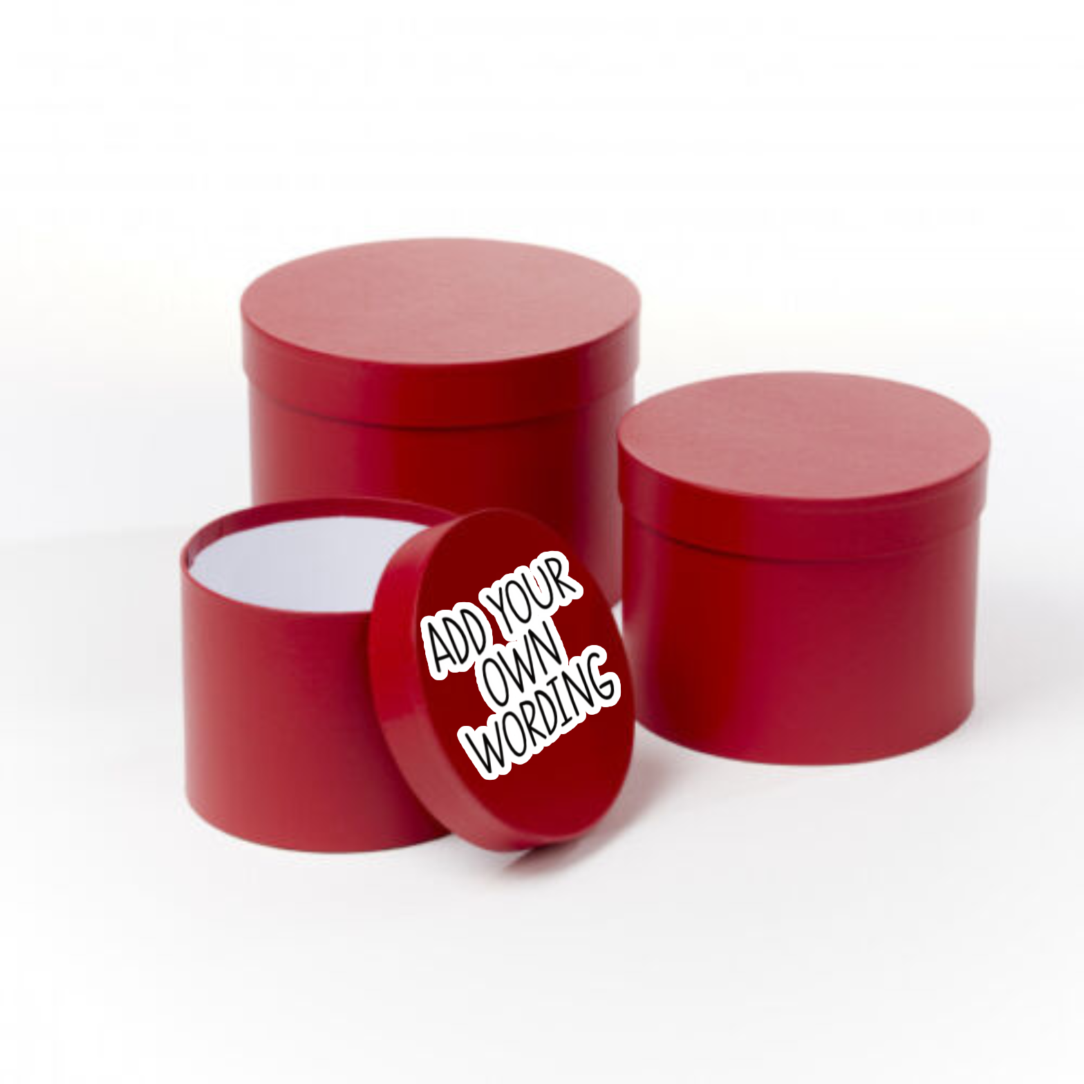 A stack of round red gift boxes with a quote printed to the lid which reads 'add your own wording' in black with a white outline.