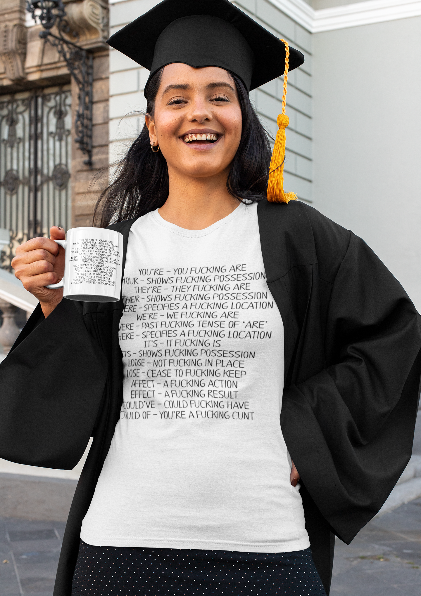 A white ceramic mug featuring funny spelling corrections such as ‘.You&#39;ve - You fucking are’ and &#39;your- shows fucking progression&#39;. Printed in black ink. It also showcases the design on a matching t-shirt.