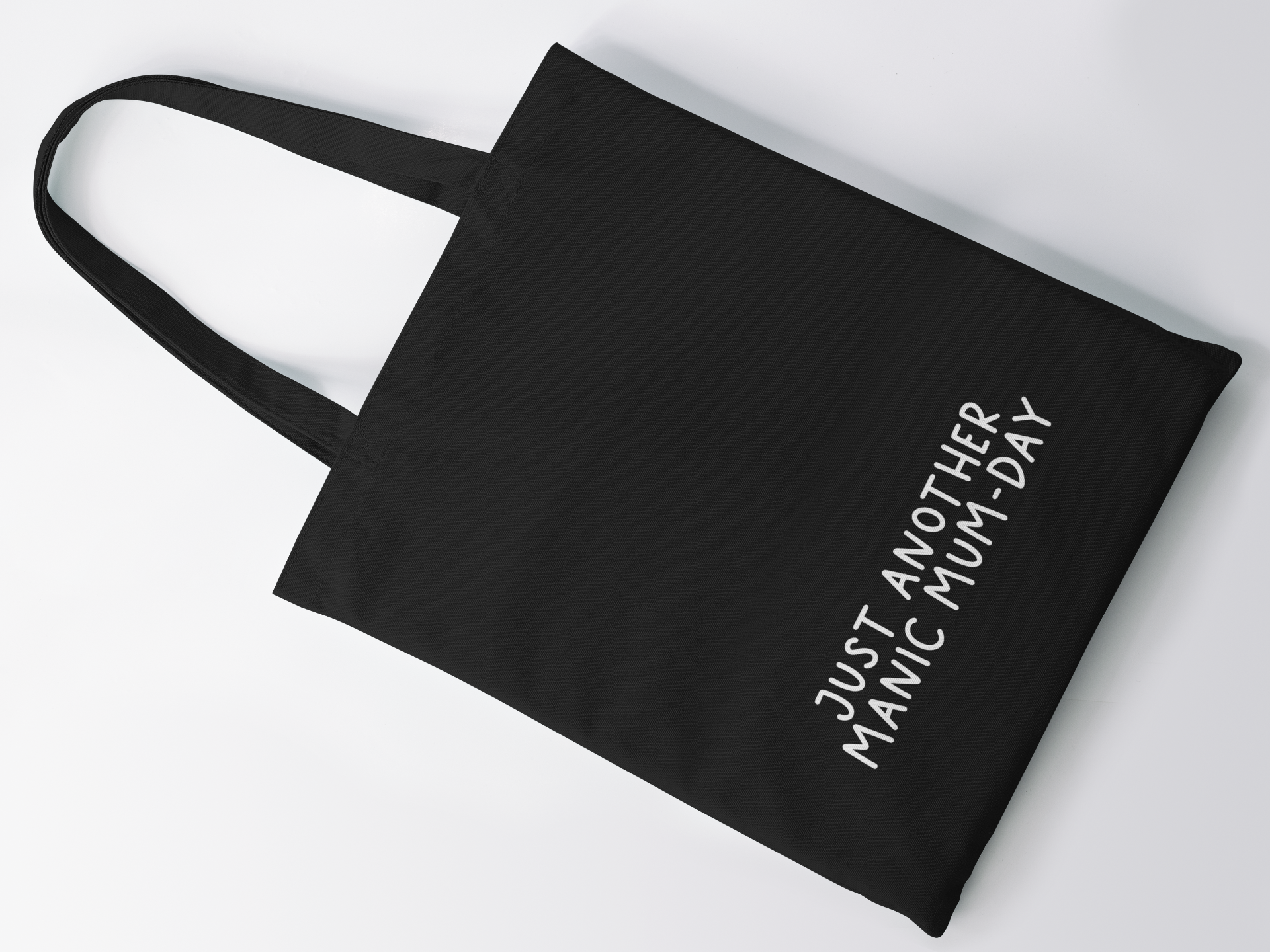 Black cotton tote bag with a quote to the bottom whoch reads 'just another manic mum-day' in white lettering.
